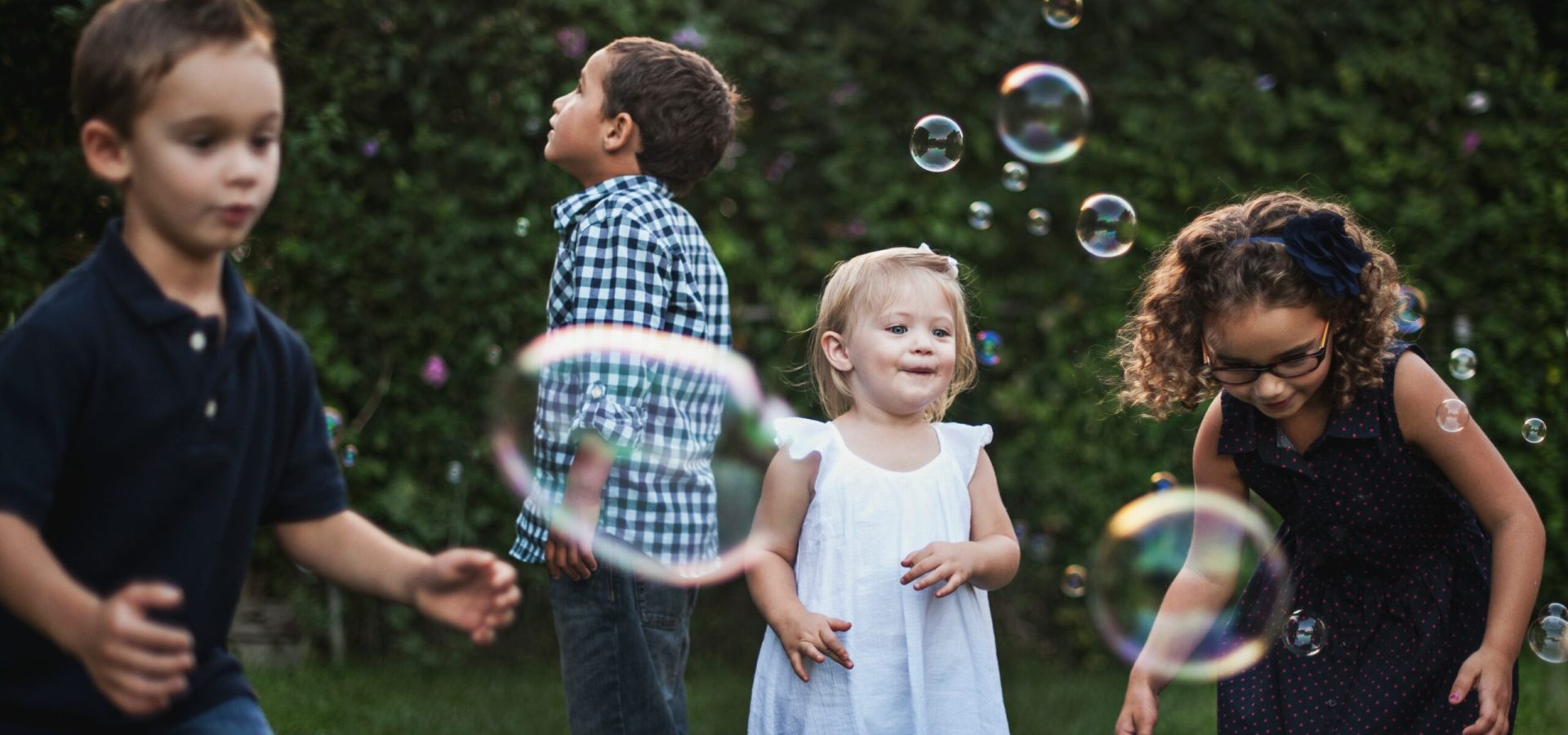 Barn som leker i trädgården med såpbubblor
